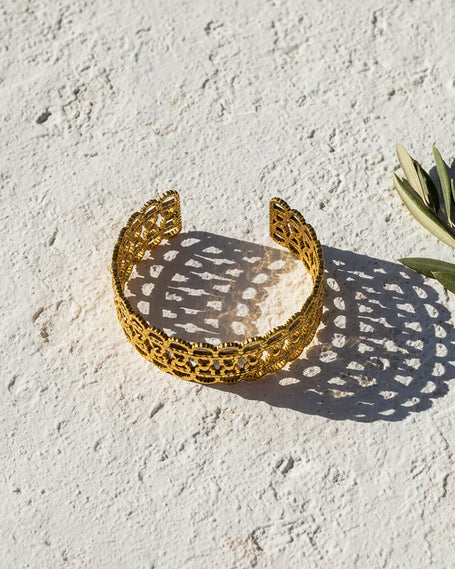 Gold tone stainless steel filigree cuff bracelet with intricate openwork design by Tereza of Naxos Store, Greece.