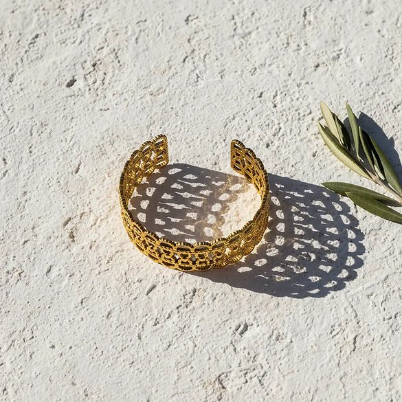 Gold tone stainless steel filigree cuff bracelet with intricate openwork design by Tereza of Naxos Store, Greece.