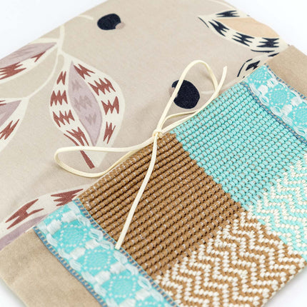 Close up of beige, brown & light blue handcrafted envelope pouch