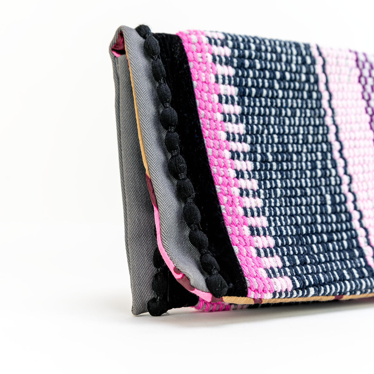 Close up of boho black pompons envelope pouch in pink