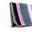 Close up of boho black pompons envelope pouch in pink
