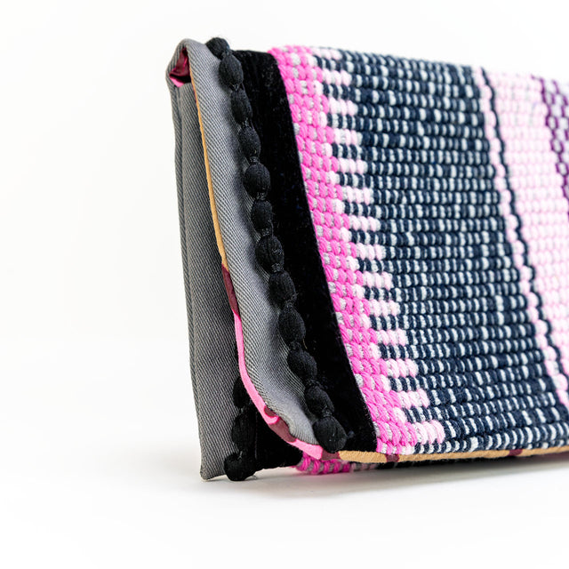 Close up of boho black pompons envelope pouch in pink