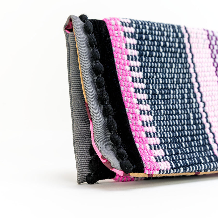 Close up of boho black pompons envelope pouch in pink
