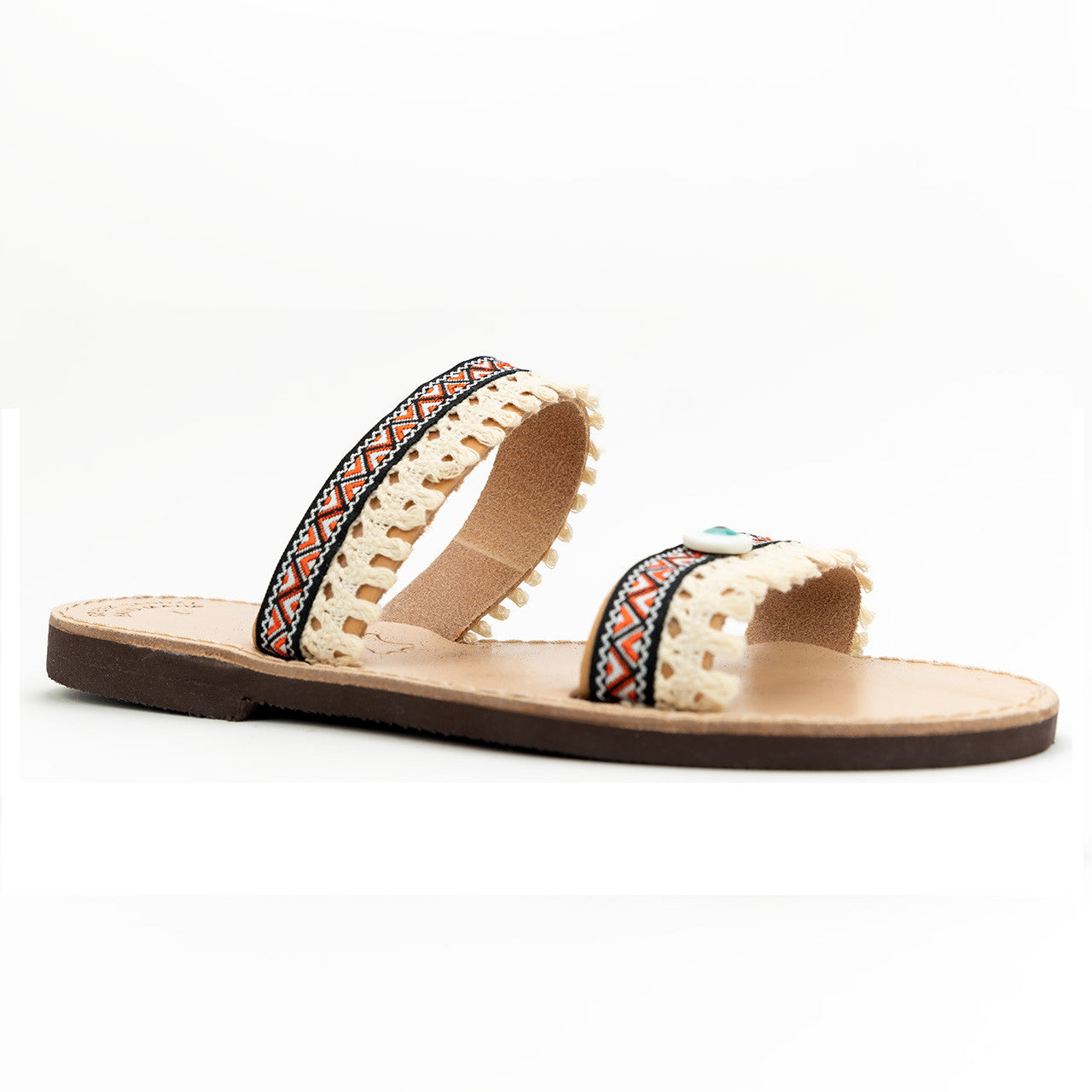 Close up of ethnic evil eye in orange, handmade leather sandals