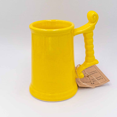 Close up of ceramic beer glass in bright yellow