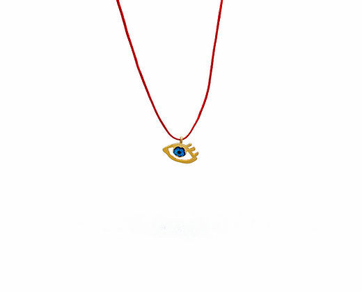 Close up of eye of gold in red, pendant in gold-plated silver