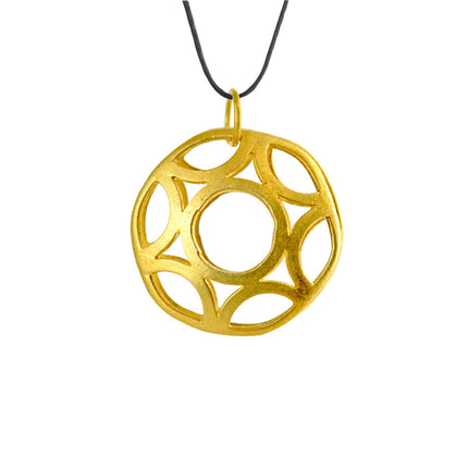 Close up of geometric circle, pendant in gold-plated silver, black lace