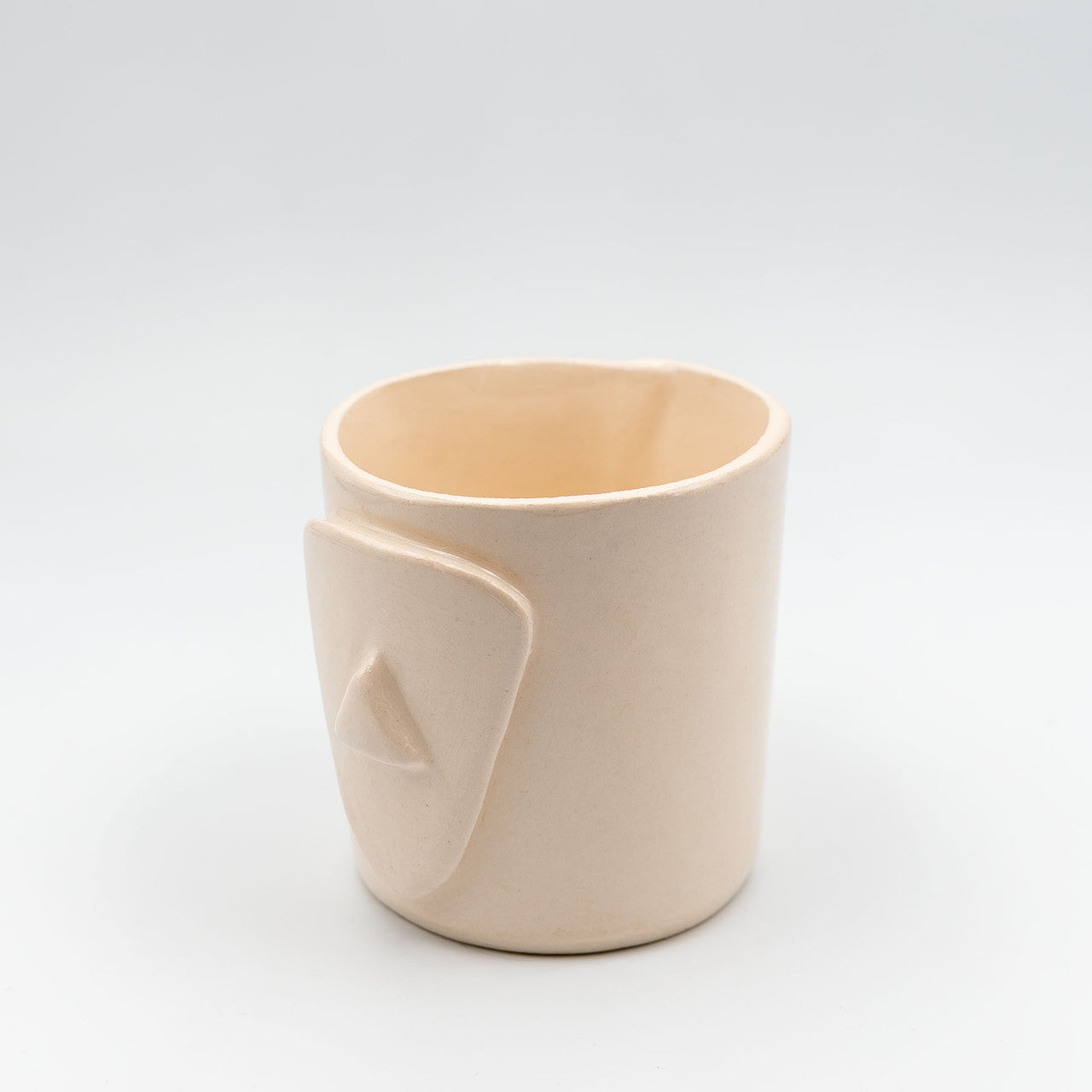 Close up of cycladian style, short ceramic mug in ivory