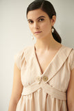 Close up of magnolia, linen dress in champagne pink