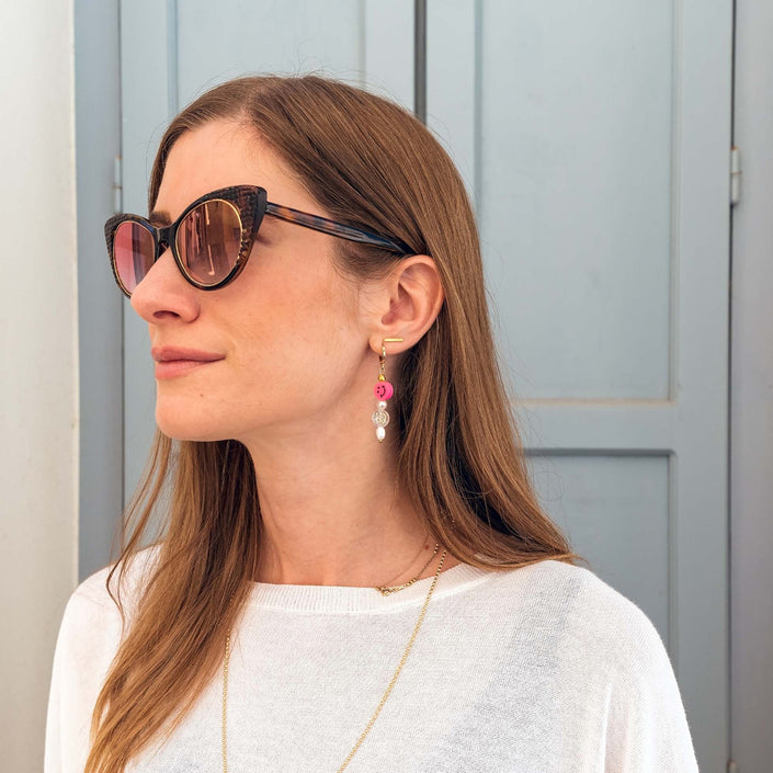 Close up of pearly double smiley hoop earrings in fuschia
