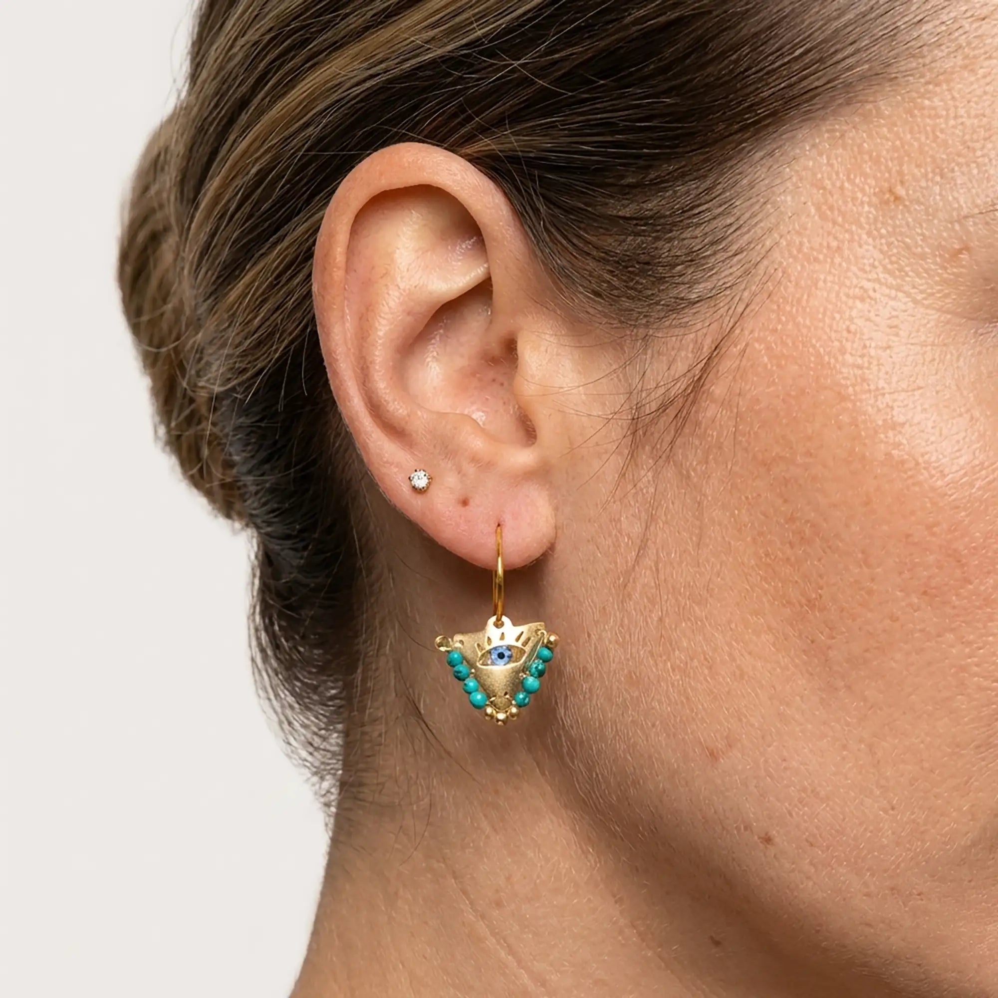 Close up of medium Aegean mint fylachto earring in gold plated sterling silver with handpainted eye