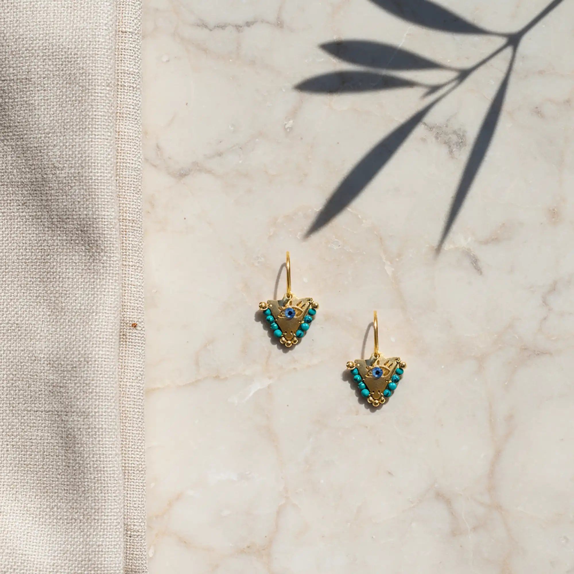 Medium Aegean mint fylachto earring on marble surface with handpainted eye and mint bead details