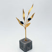 Close up of golden olive branch in black, handcrafted