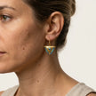 Woman wearing medium blue fylachto earrings in gold plated sterling silver by the sea
