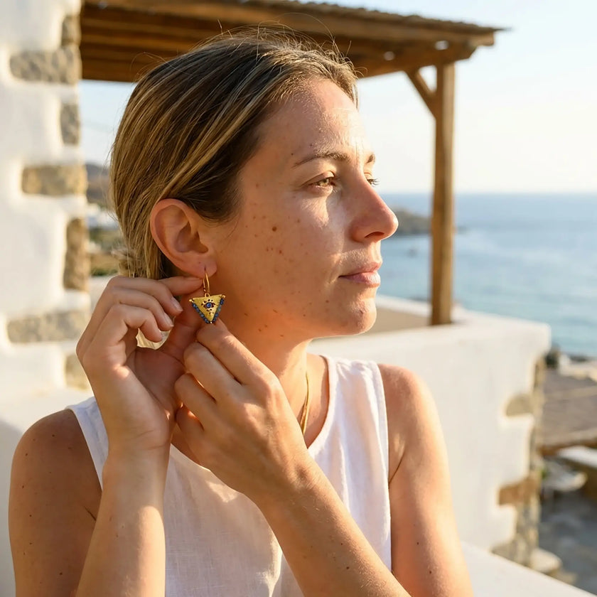 Close up of medium blue fylachto earring in gold plated sterling silver with handpainted blue eye