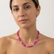 Bold fuchsia beaded necklace with white pearls worn by model in Mediterranean setting