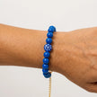 Woman wearing a handmade blue bead bracelet with central evil eye bead
