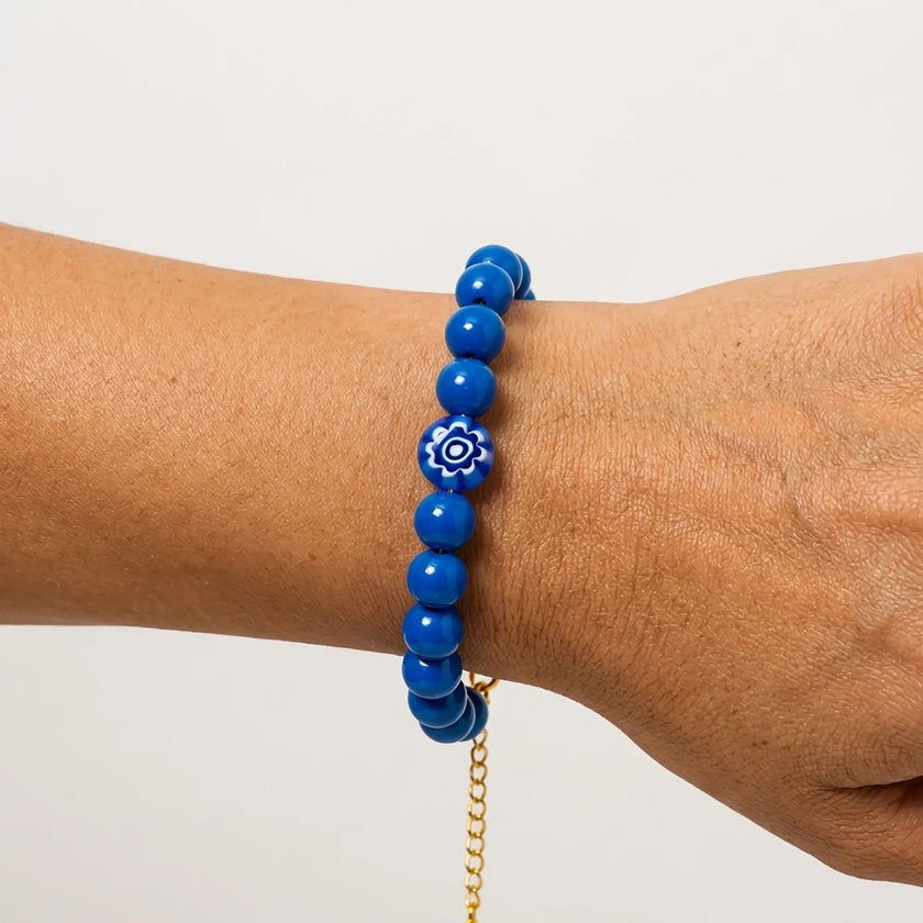 Woman wearing a handmade blue bead bracelet with central evil eye bead