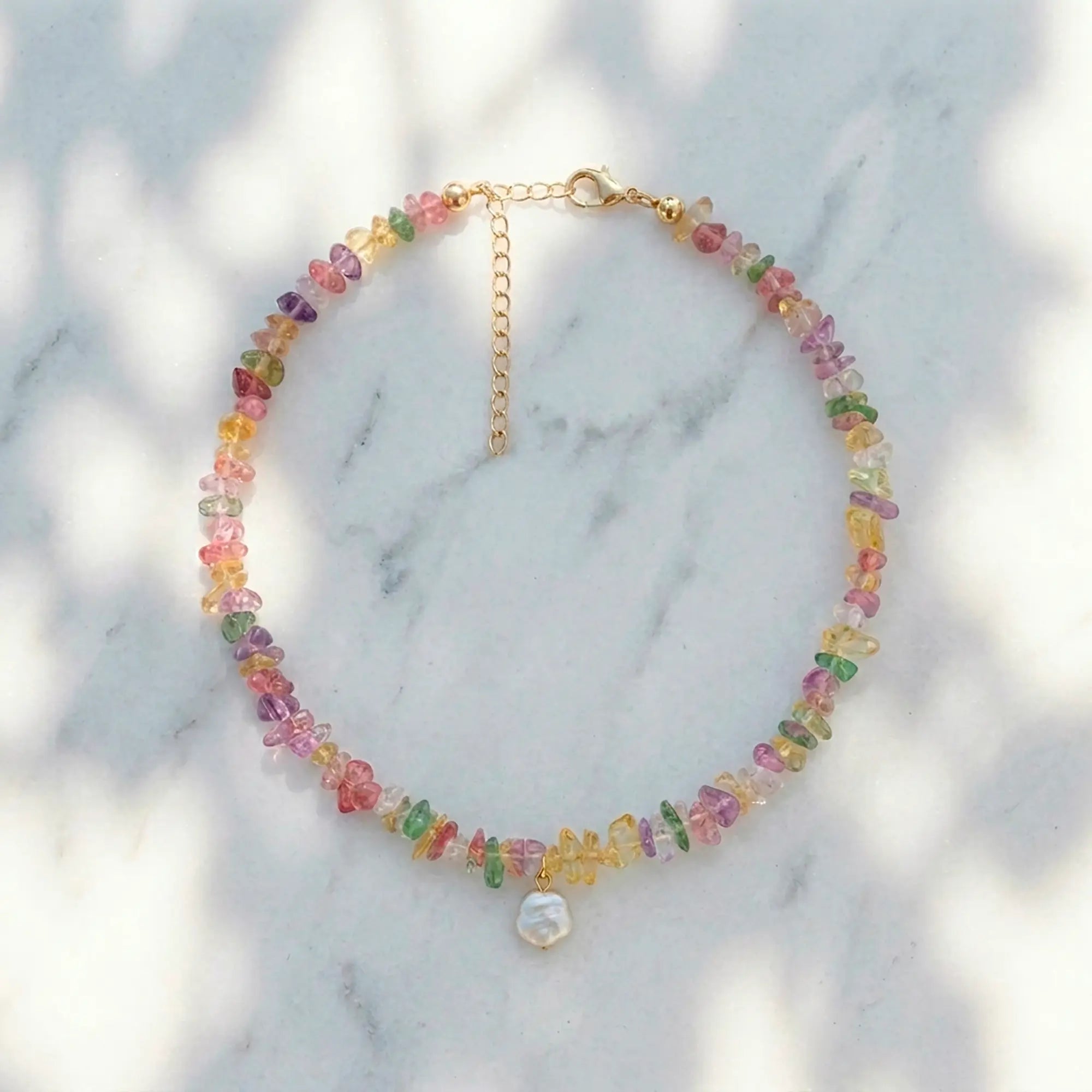 Drosia pastel stone necklace with freshwater pearl styled on marble