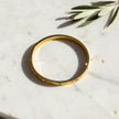 Gold tone stainless steel evil eye bangle bracelet with polished finish and multicolor crystal accents