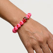 Woman wearing a handmade pink heart bracelet with Murano strawberry bead