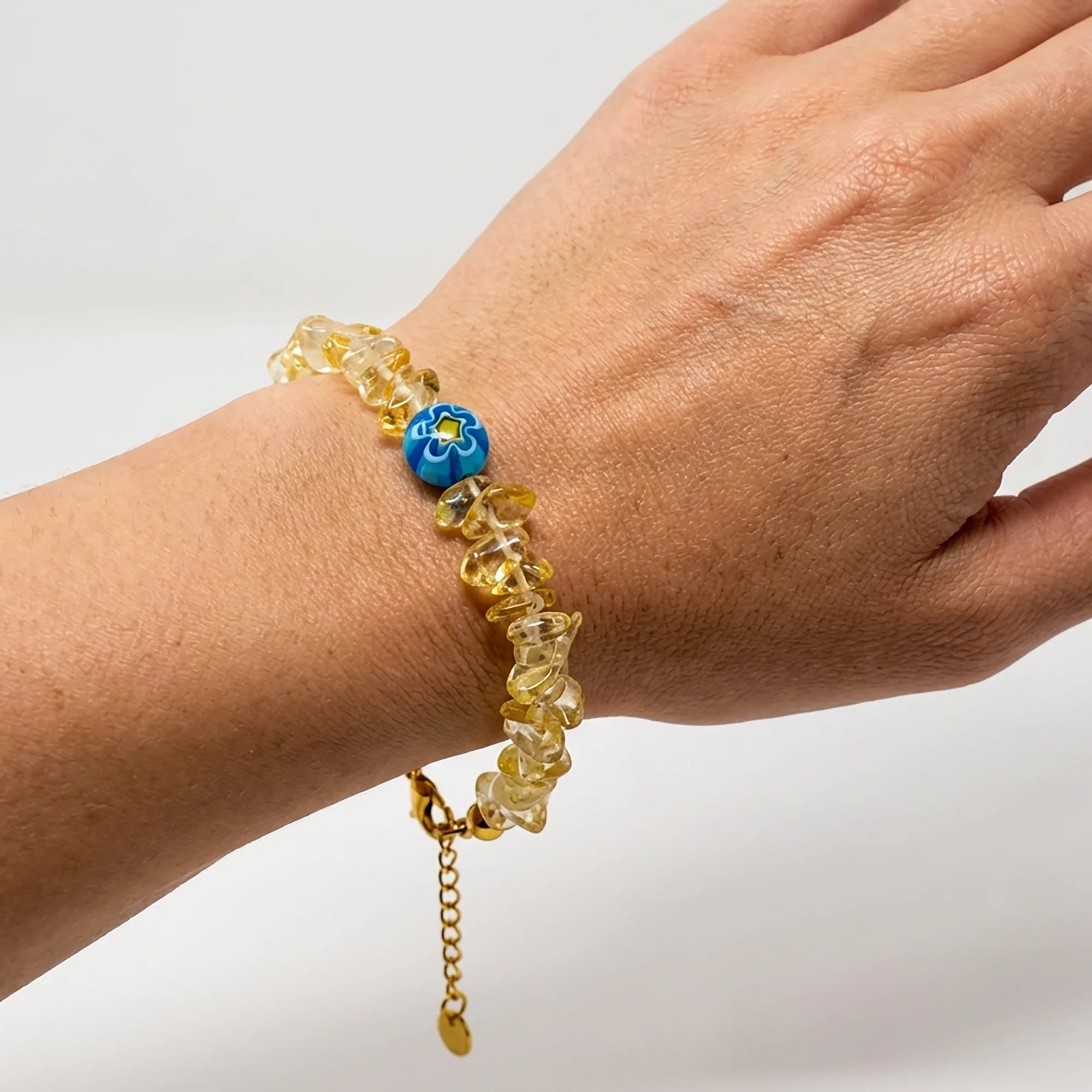 Woman wearing a handmade golden chip bead bracelet with blue Murano bead