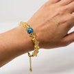 Woman wearing a handmade golden chip bead bracelet with blue Murano bead