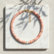 Koralli coral shell disc necklace with Murano glass flower bead styled on marble
