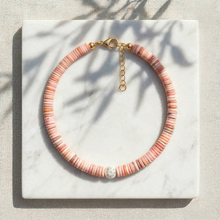 Koralli coral shell disc necklace with Murano glass flower bead styled on marble