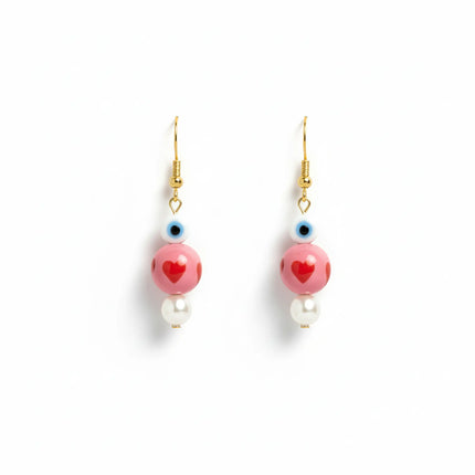 Handmade earrings from Naxos with pink heart beads, evil eye detail, and pearl drops