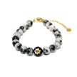 Close-up of adjustable beaded bracelet with marbled stone beads and Murano glass daisy