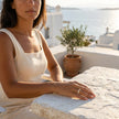 Woman sitting on a stone ledge with a scenic background