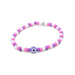 Close-up of a stretch seed bead bracelet in pink purple and white with evil eye centrepiece