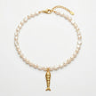Psari pearl necklace with gold plated fish pendant flat lay on white background