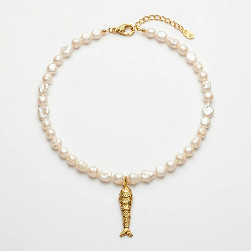 Psari pearl necklace with gold plated fish pendant flat lay on white background