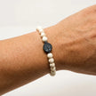 Woman wearing a handmade white stone bracelet with tree of life centerpiece