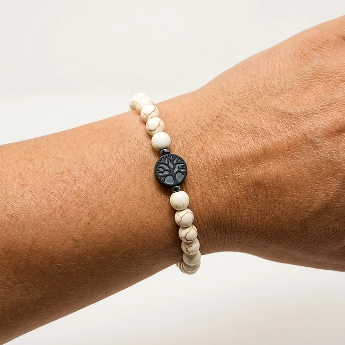 Woman wearing a handmade white stone bracelet with tree of life centerpiece