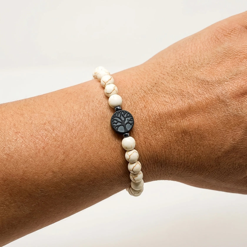 Woman wearing a handmade white stone bracelet with tree of life centerpiece